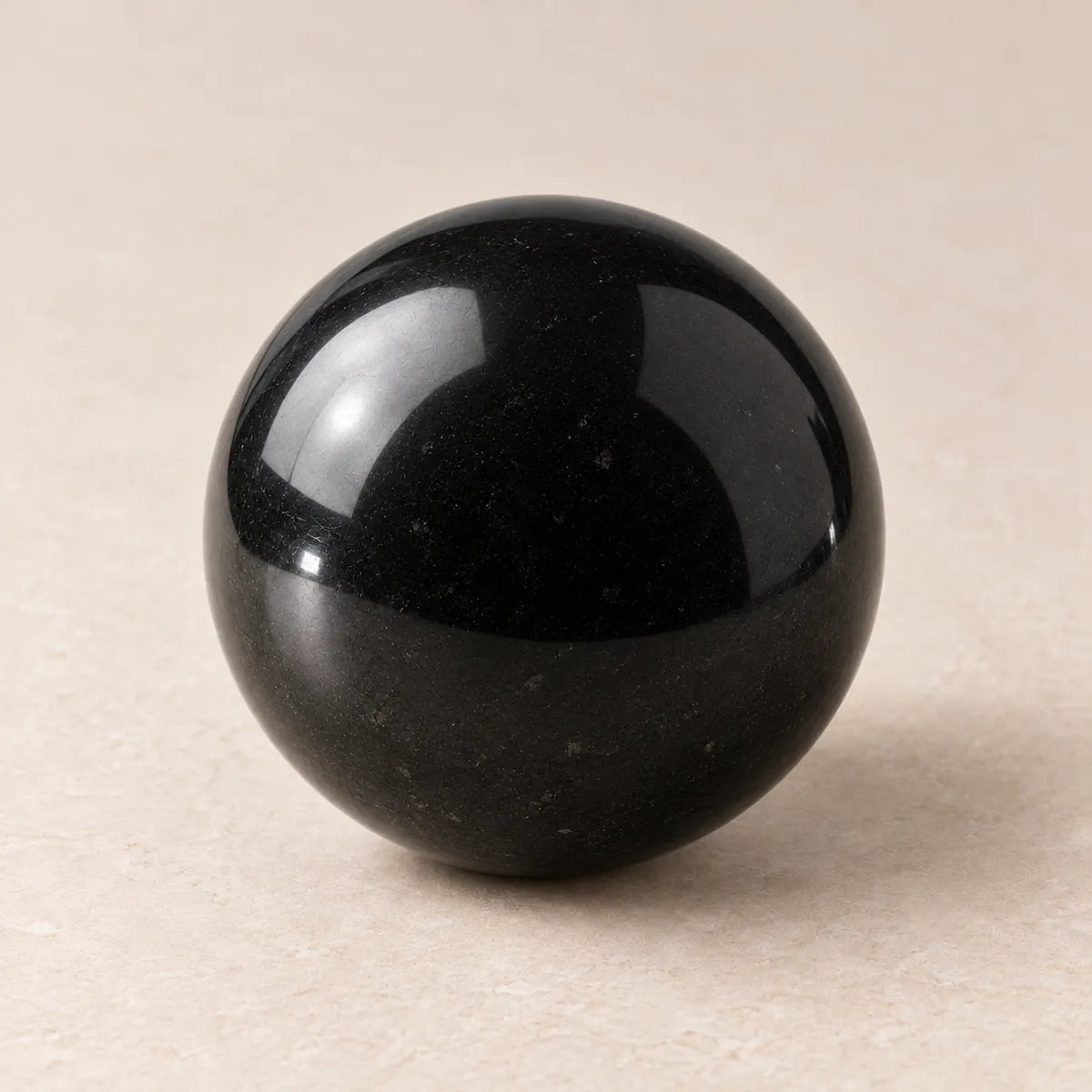 Sfera lucidata in shungite, su fondo chiaro