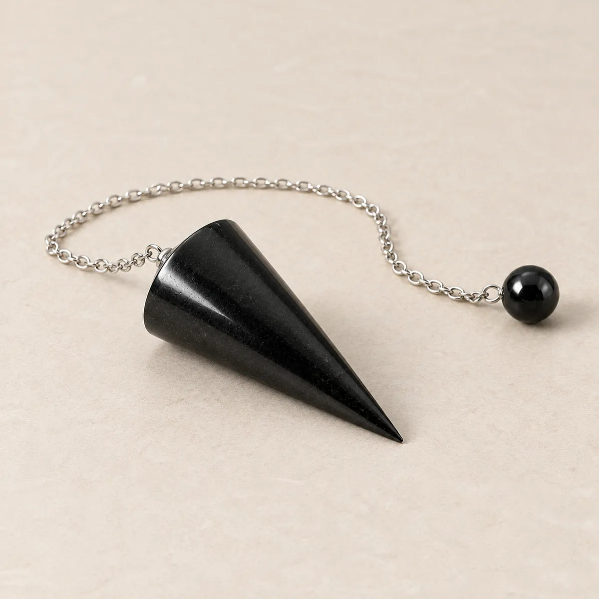 Pendolo in shungite, su fondo chiaro