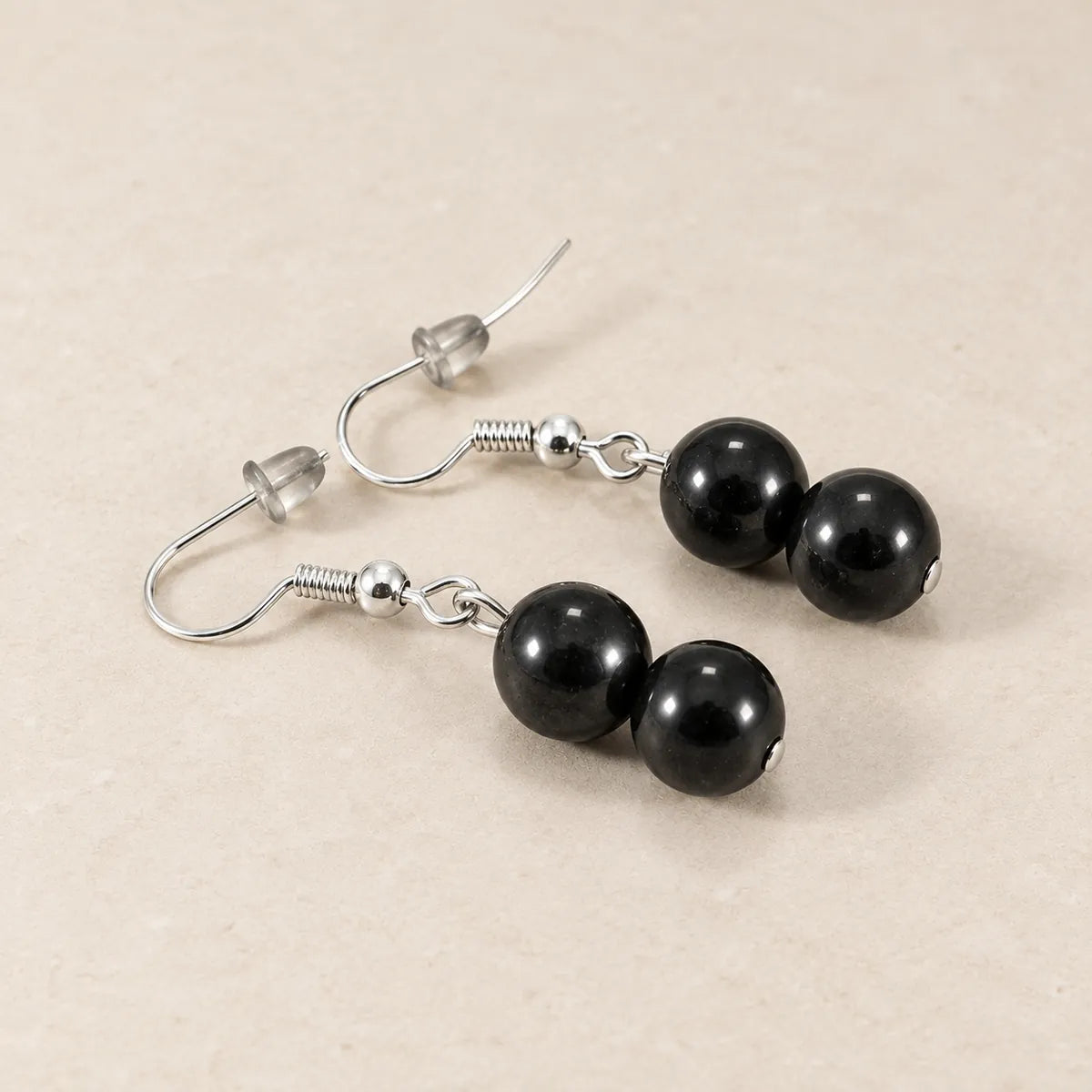 Orecchini con due perline in shungite, 10 mm, su fondo chiaro