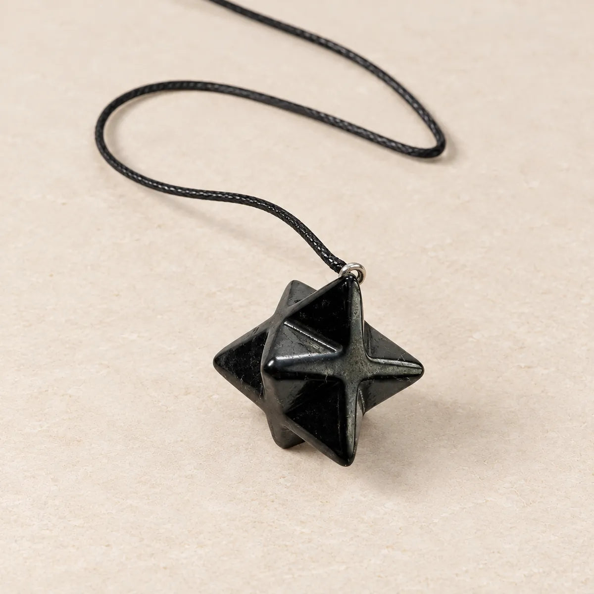 Pendente Merkaba 2 cm in shungite, su fondo chiaro