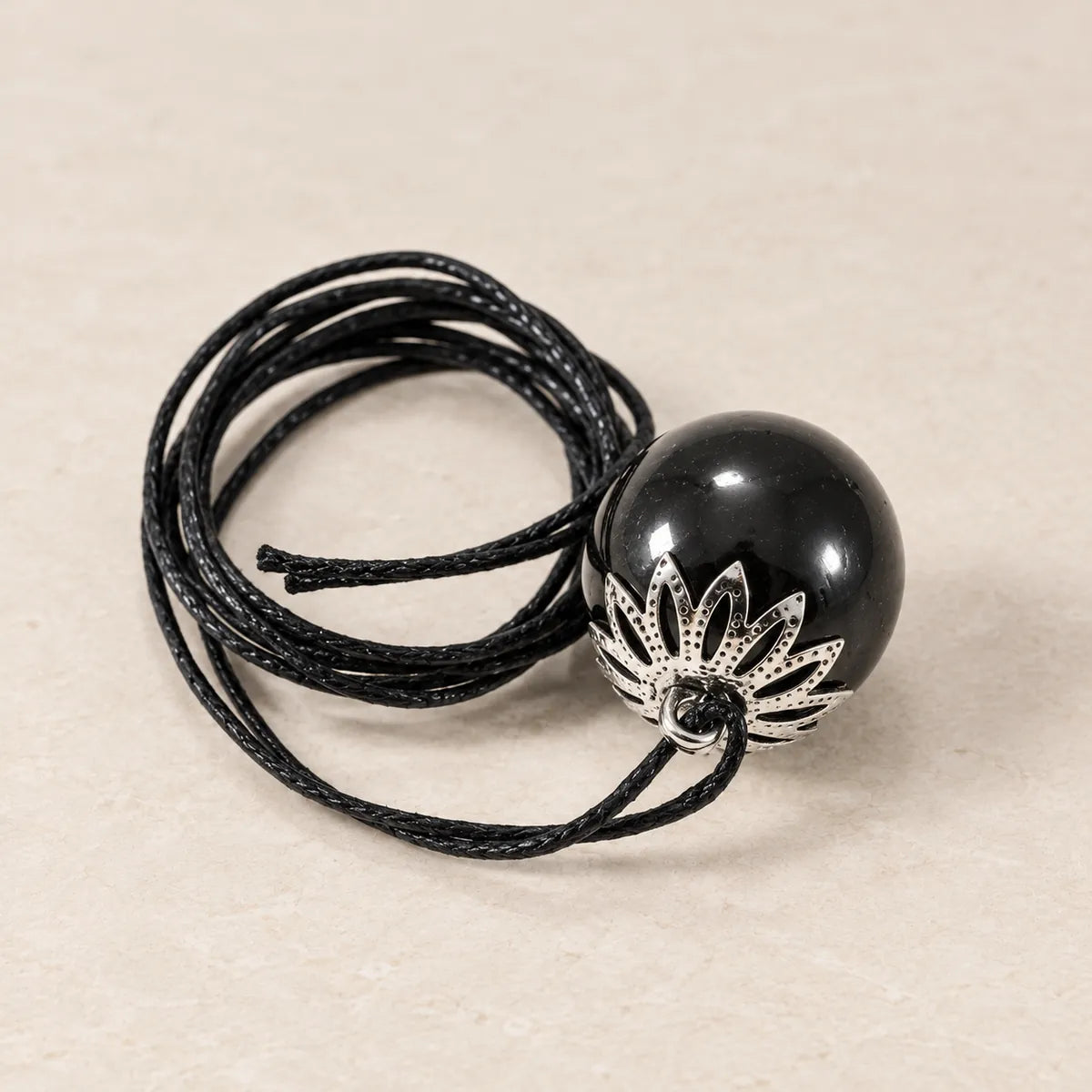 Pendente perlina careliana lucidata 20 mm in shungite, su fondo chiaro