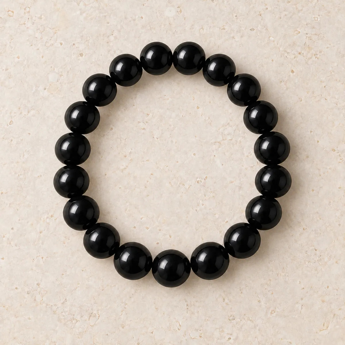 Bracciale Black Pearl 10 mm in shungite, su fondo chiaro