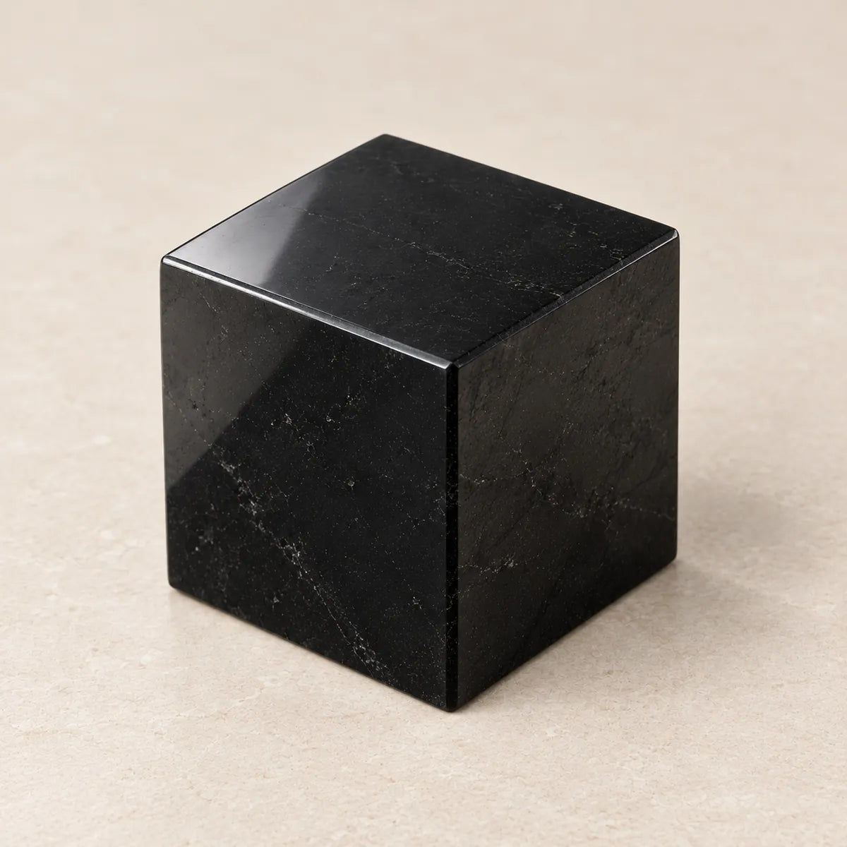 Cubo lucidato in shungite, su fondo chiaro