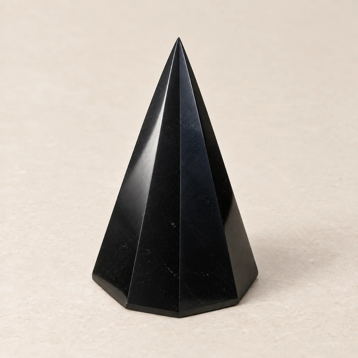 Piramide 8 lati in shungite, su fondo chiaro