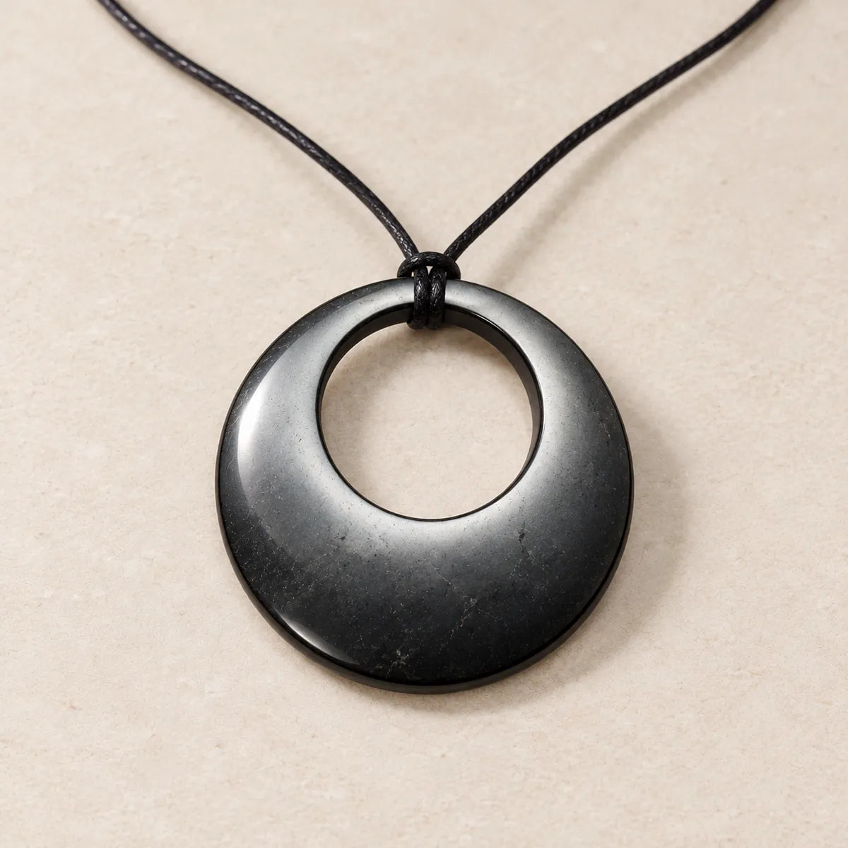 Pendente cerchio nel cerchio in shungite, su fondo chiaro
