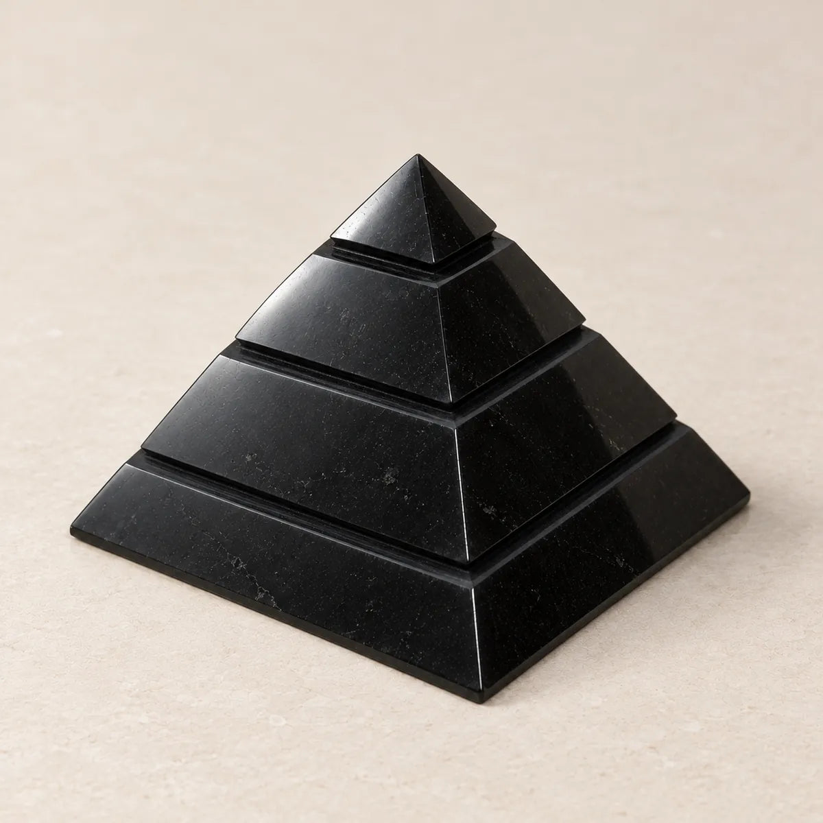 Piramide Saqqara lucidata in shungite, su fondo chiaro