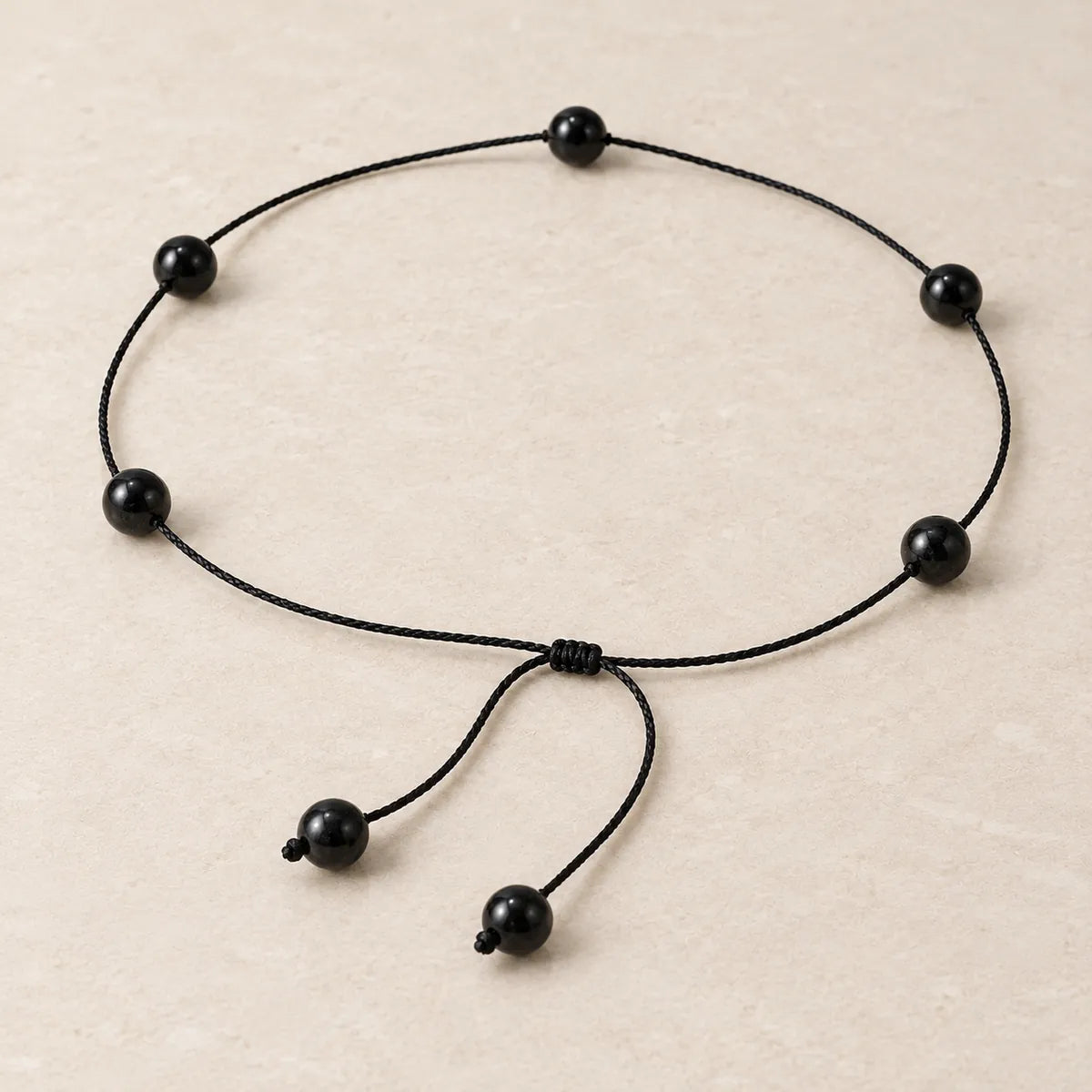 Collana Dot con chiusura orientale 8 mm in shungite, su fondo chiaro
