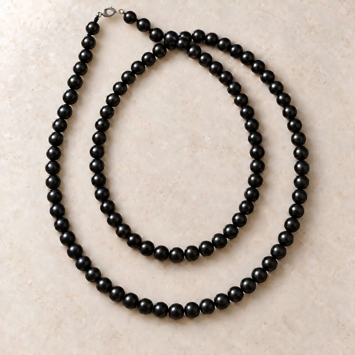 Collana Polar Light 8 mm – 100 pezzi in shungite, su fondo chiaro