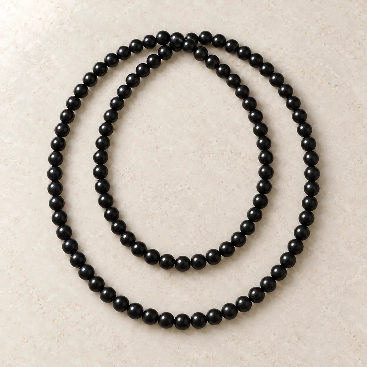 Collana Polar Light 8 mm – 100 pezzi in shungite, su fondo chiaro