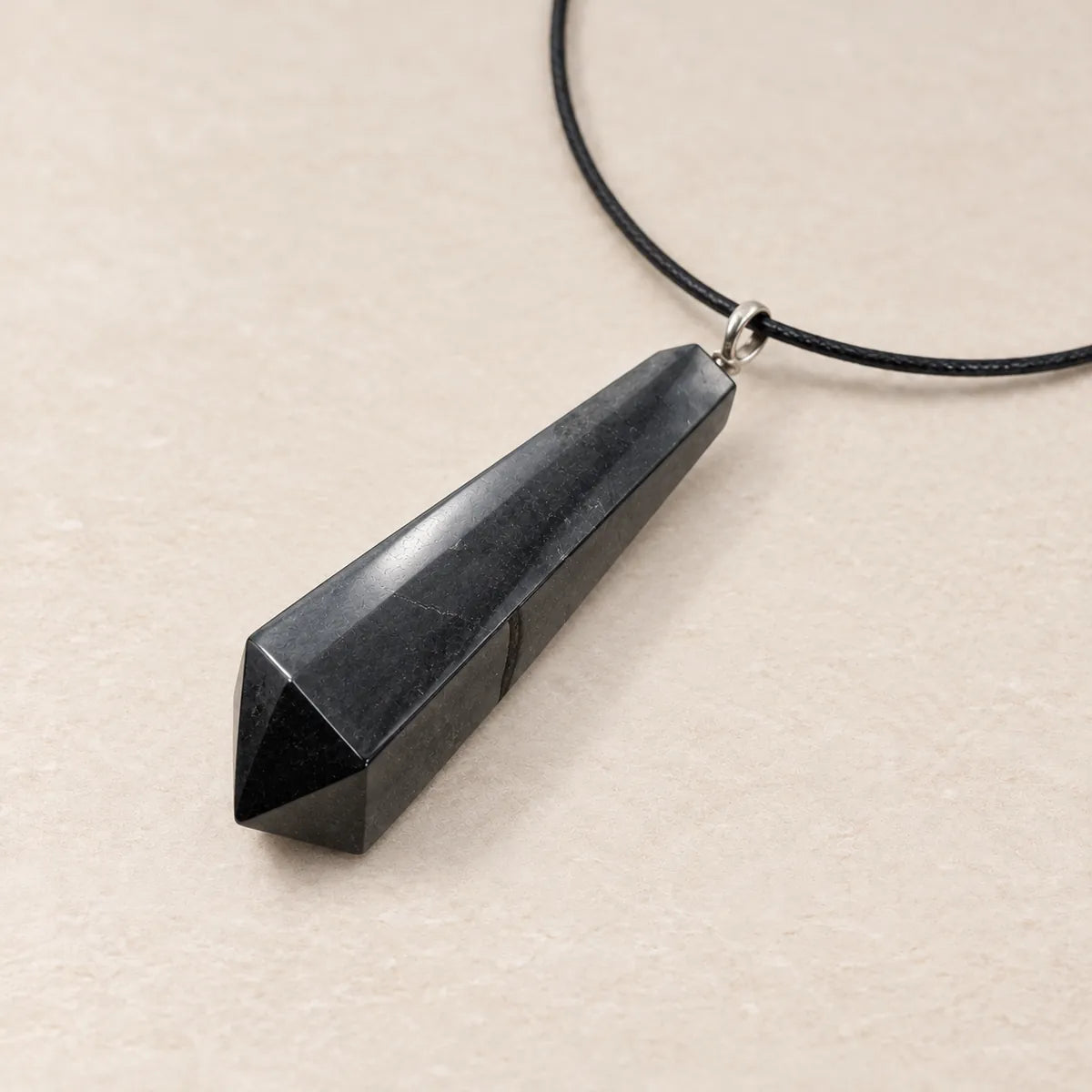 Pendente pendolo in shungite, su fondo chiaro