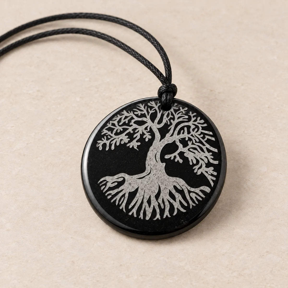 Pendente cerchio 30 mm inciso in shungite, Albero della Vita, su fondo chiaro