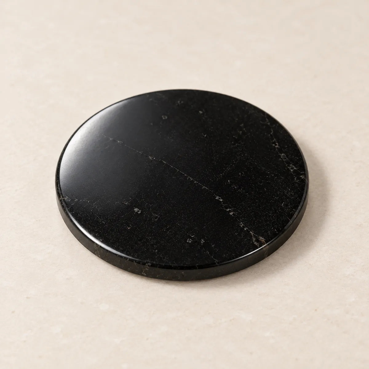 Disco circolare lucidato in shungite, 30 mm, su fondo chiaro