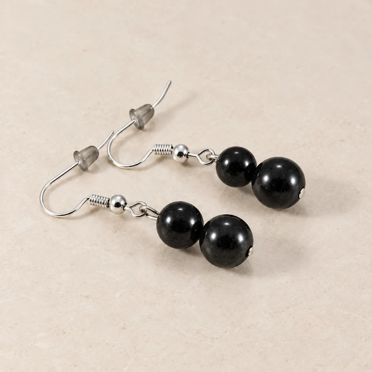 Orecchini con due perline in shungite, 8 mm + 10 mm, su fondo chiaro