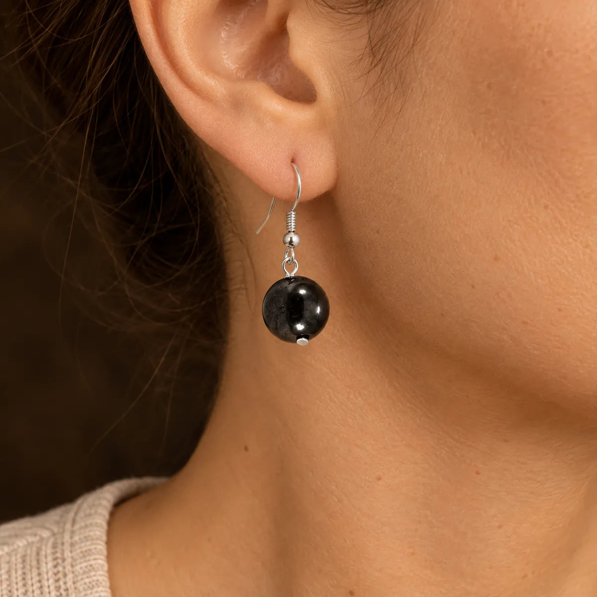 Orecchini con una perlina in shungite, indossati