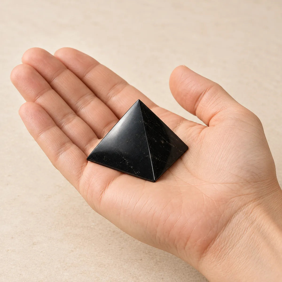 Piramide lucidata in shungite, tenuta in mano