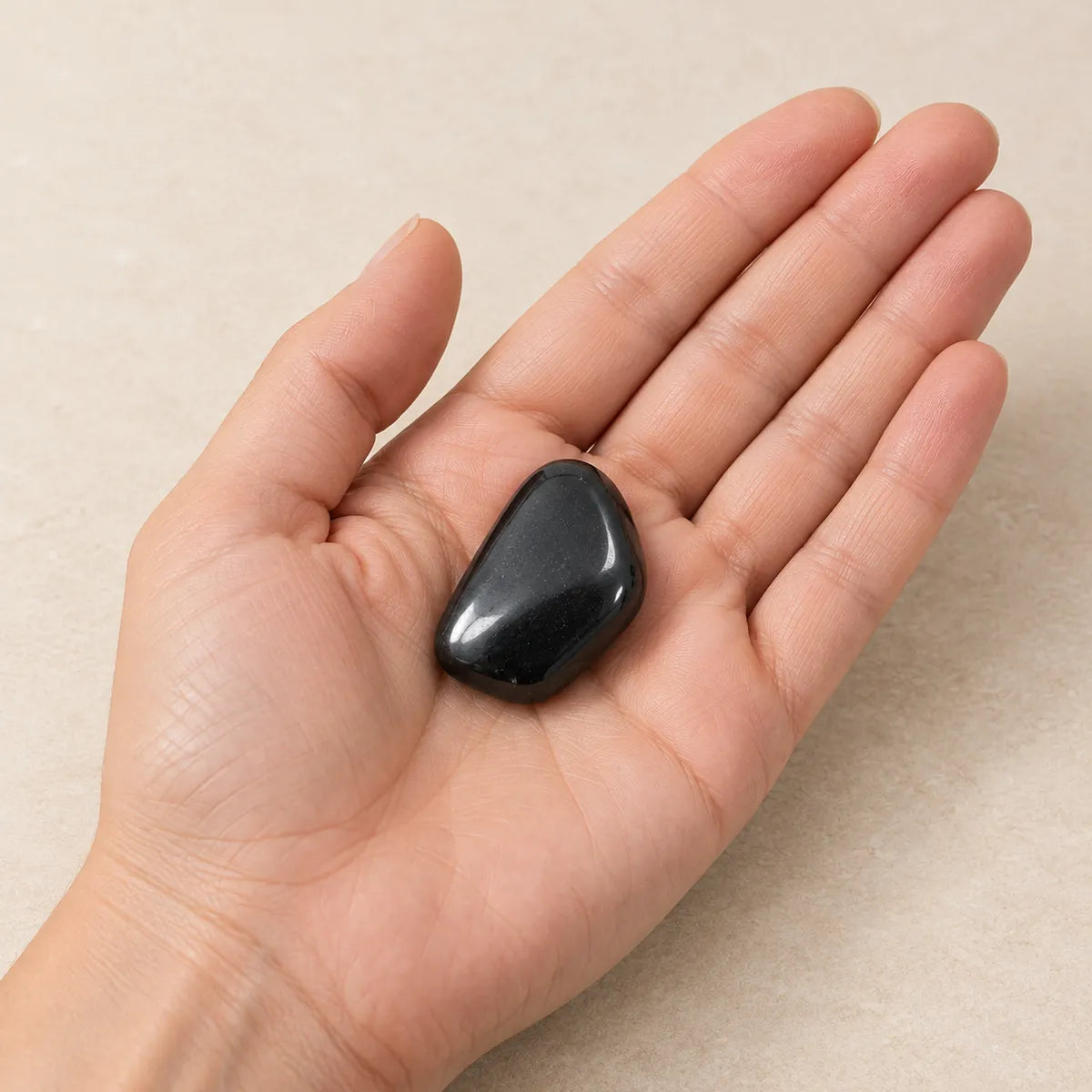 Pietre burattate lucidate 2-4 cm in shungite, tenute in mano