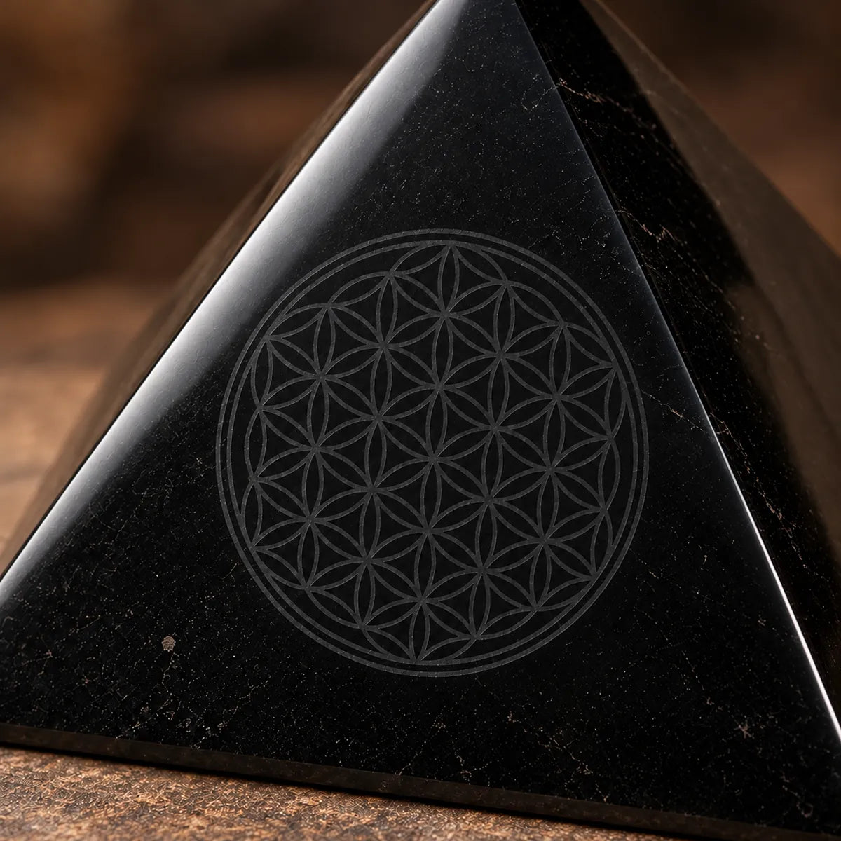 Piramide lucidata con Fiore della Vita inciso in shungite, un dettaglio da vicino
