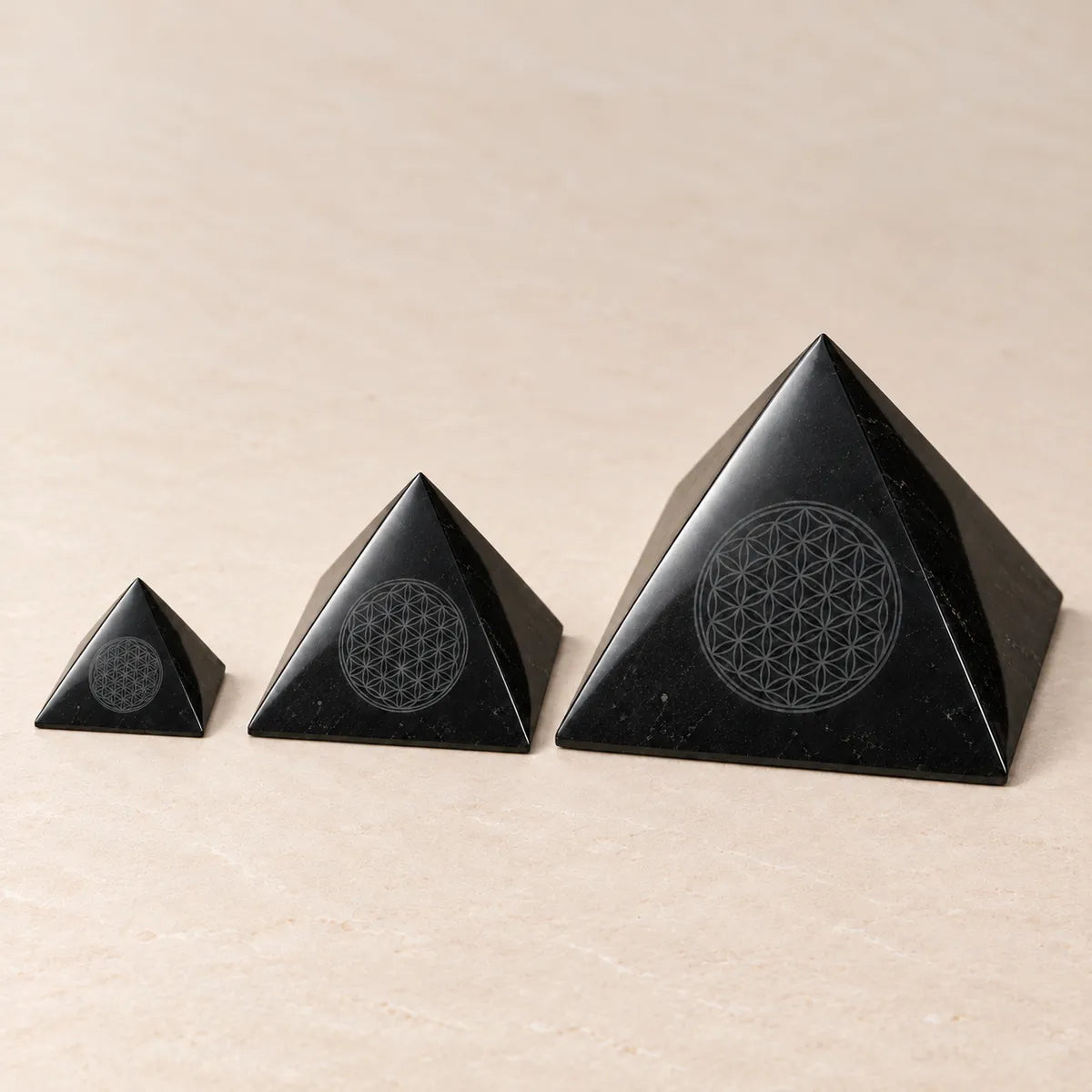 Piramide lucidata con Fiore della Vita inciso in shungite: tre misure a confronto, 5, 10 e 15 cm