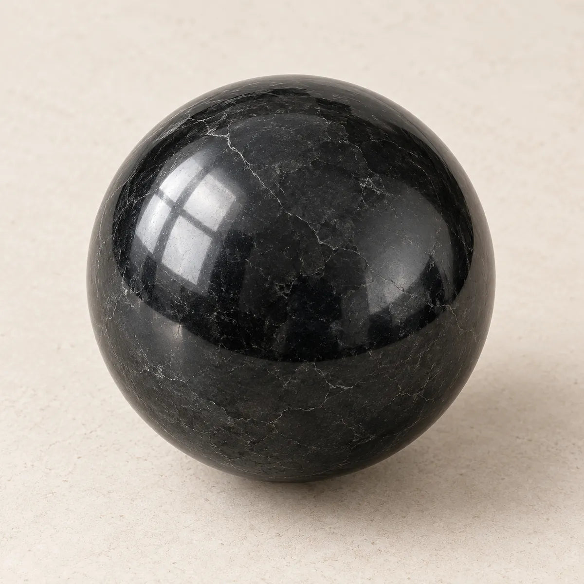 Sfera in shungite lucidata su fondo chiaro